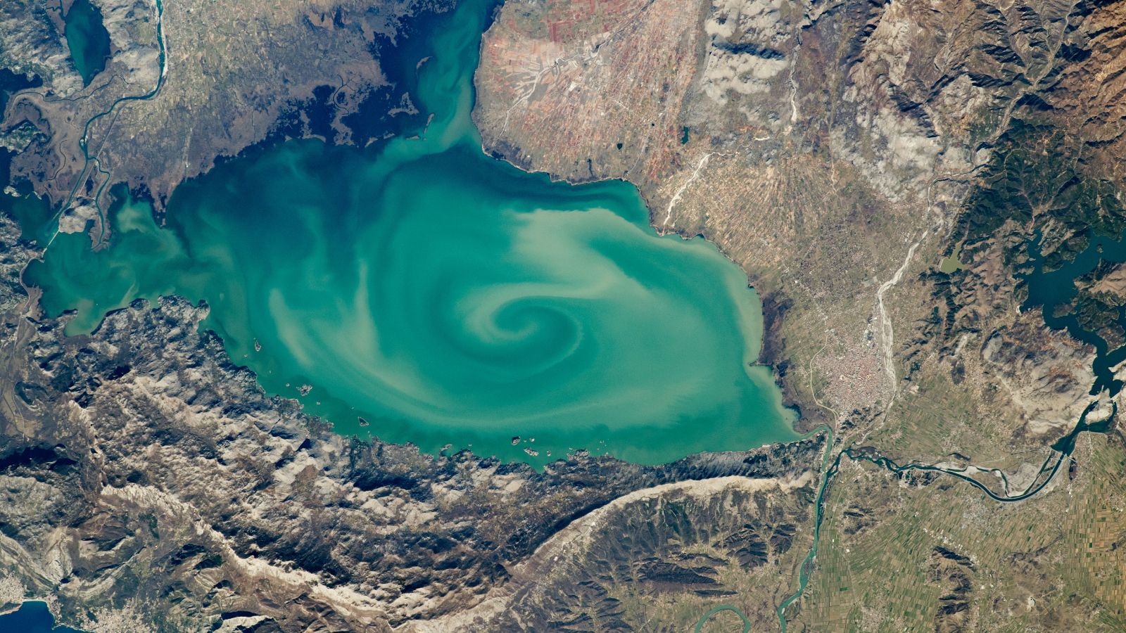 Giant, Milky-Green Vortex Swirls Across Massive 'Cryptodepression' Lake in Southern Europe